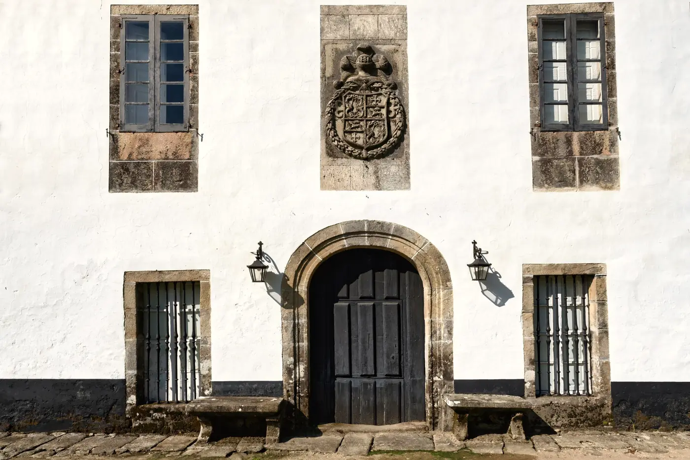 La portada del pazo, con el escudo sobre el arco de piedra